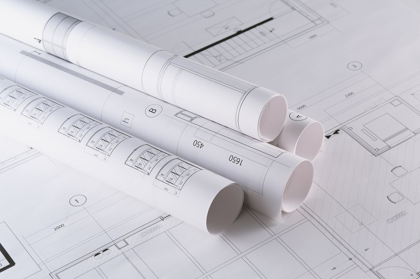 Rolled construction drawings on an open plan set